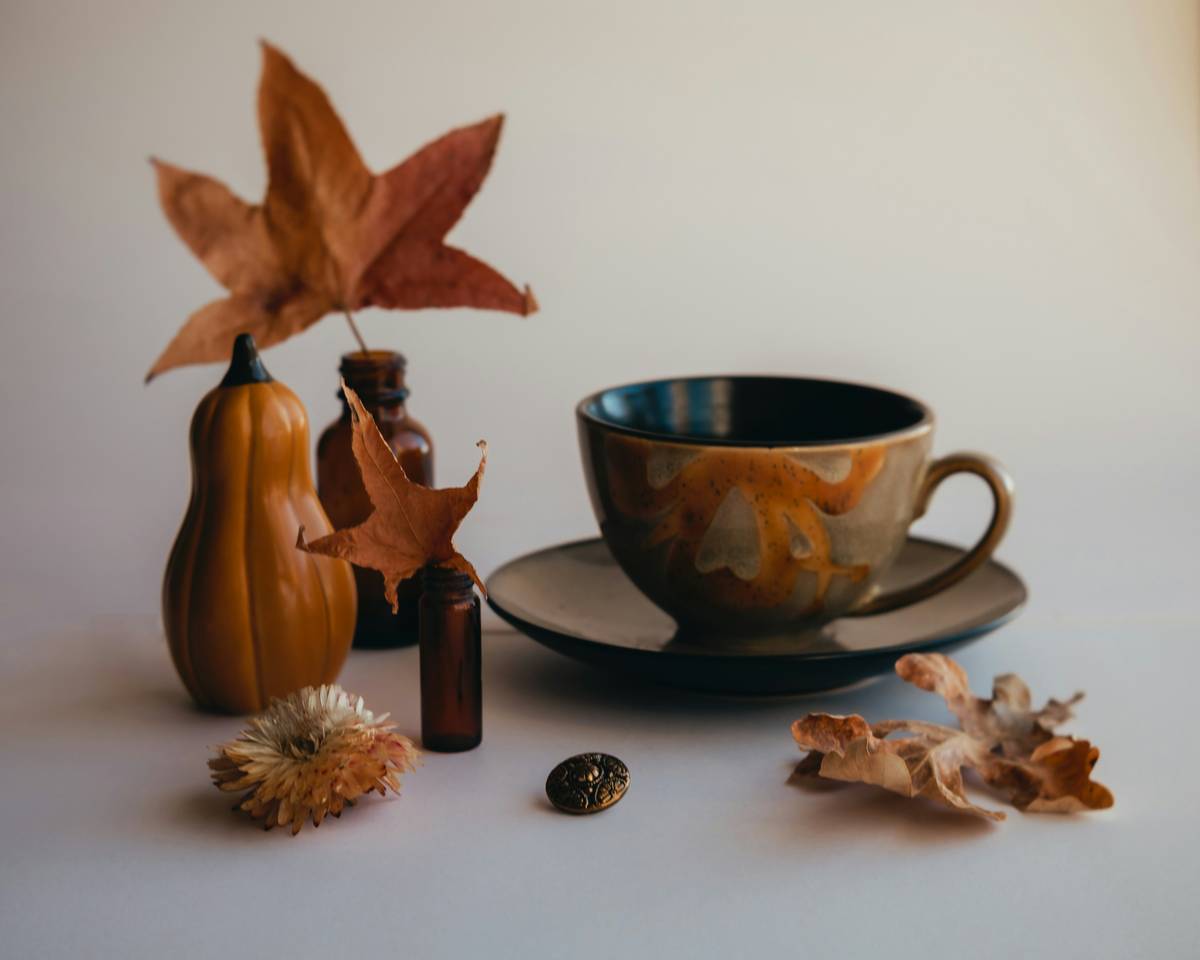 thanksgiving home decoration ideas featuring a minimalist tablescape with eucalyptus, white pumpkins, and amber candles