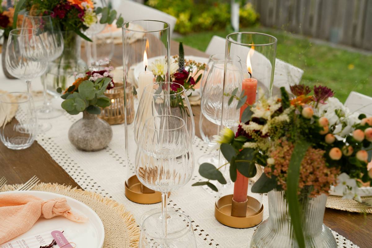 thanksgiving table decor outdoor with rustic wooden table, pumpkins, burlap runner, and hurricane lanterns