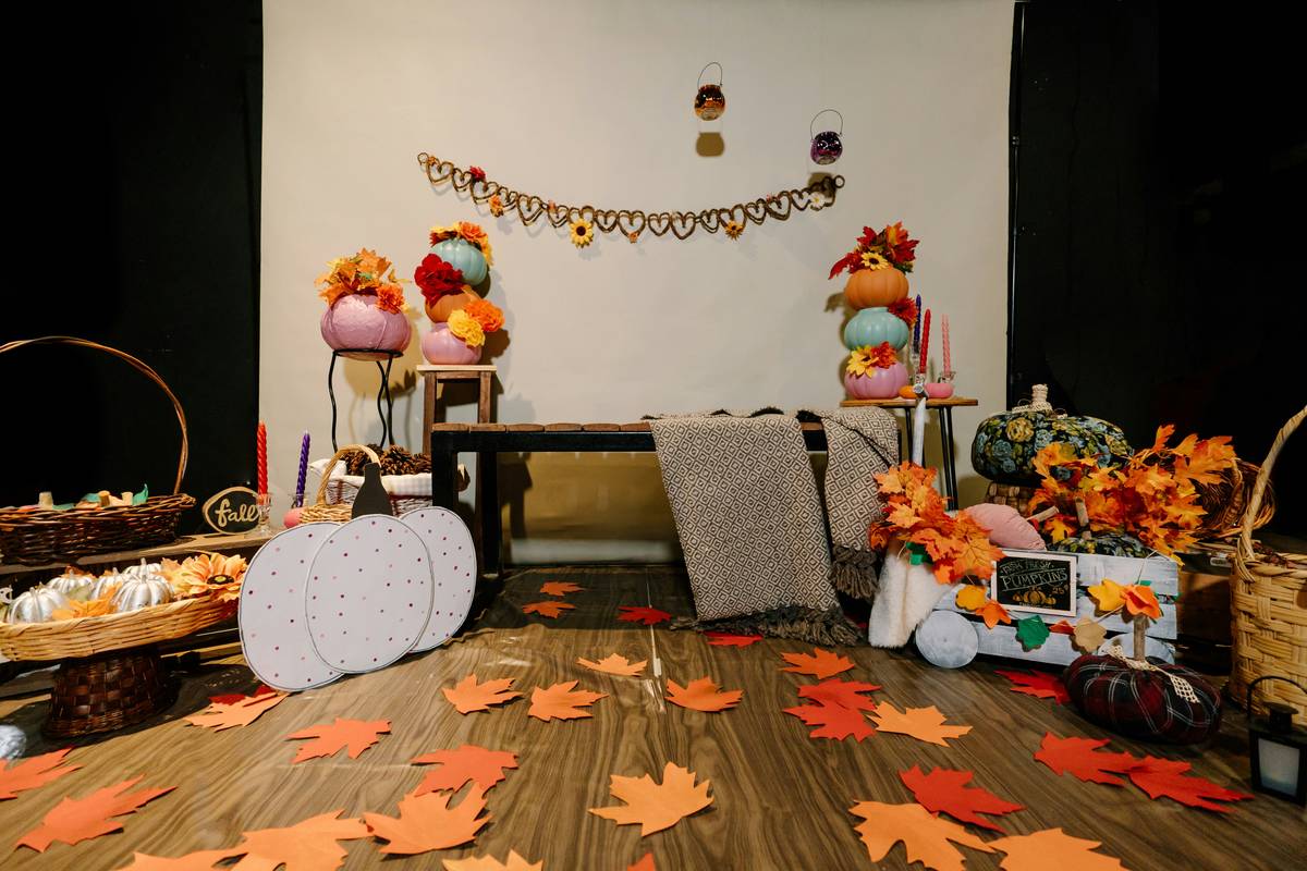 Cozy dining table with at home thanksgiving decorations featuring pumpkins, candles, and burlap runner
