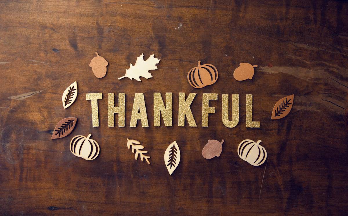 special occasion thanksgiving table decor kid featuring child-safe fabric pumpkins, wooden place settings, and flameless candles on a rustic table